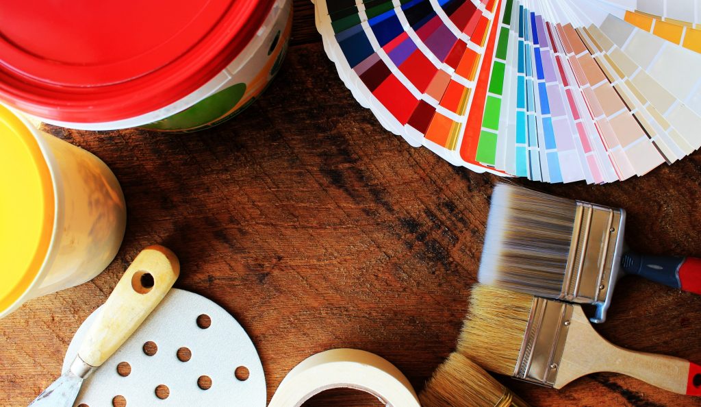 various painting tools and color palette on wooden background