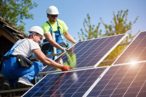 two solar installers installing heavy solar panels