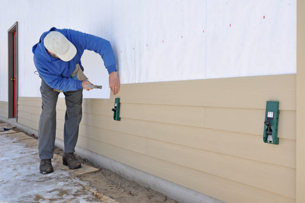man installing fibrous cement siding