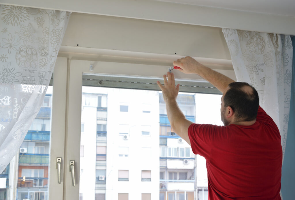 man measuring and marking a position on the wall