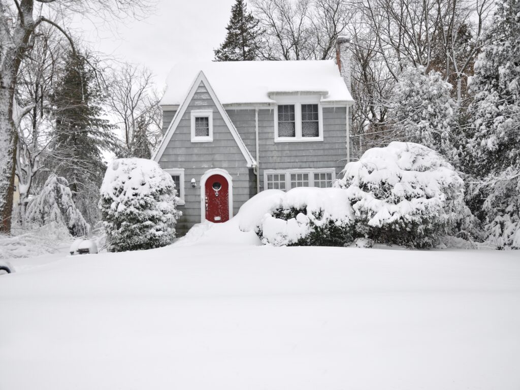 snow covered suburban grey cottage