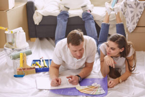 young couple looking at different paint colors and laying on floors