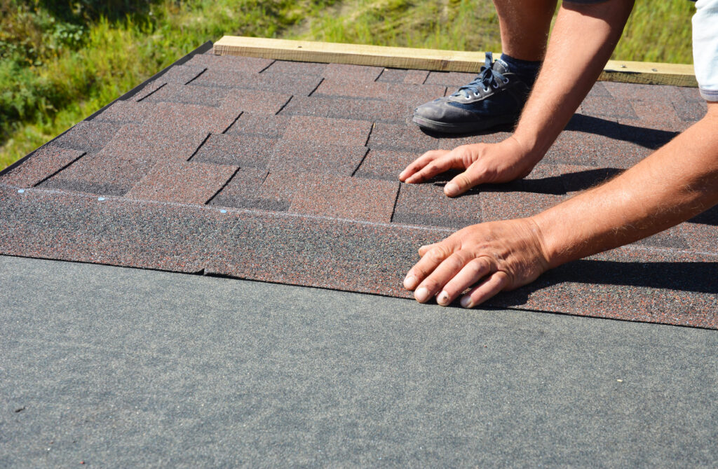 a building contractor installing asphalt shingles