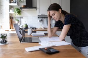 concerned young woman at home looking over paperwork