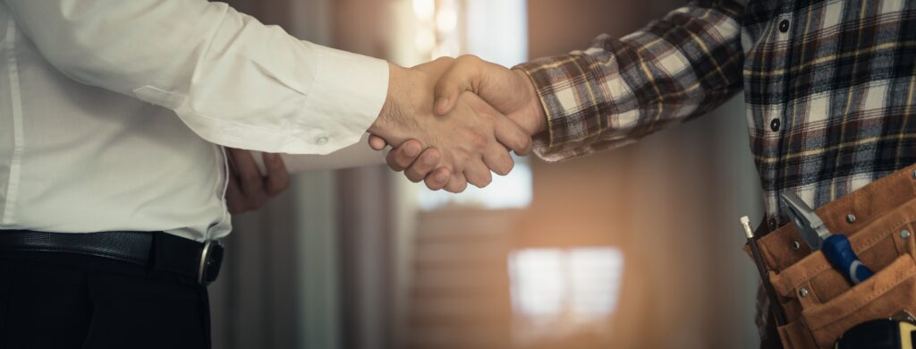 close up of construction worker and client shaking hands