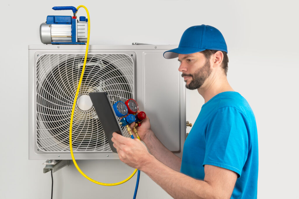 An HVAC professional checking the pressure readings of a residential HVAC unit