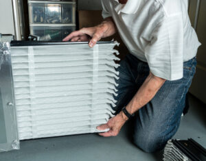 A homeowner installing a new air filter for their HVAC system.