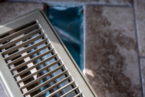 An image of a vent being taken off of an air duct channel in preparation for a cleaning.