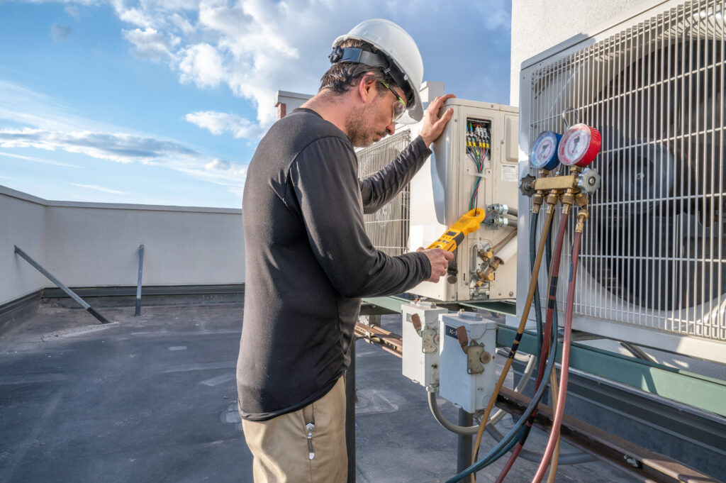 An HVAC technician checking the electrical current of an HVAC system.