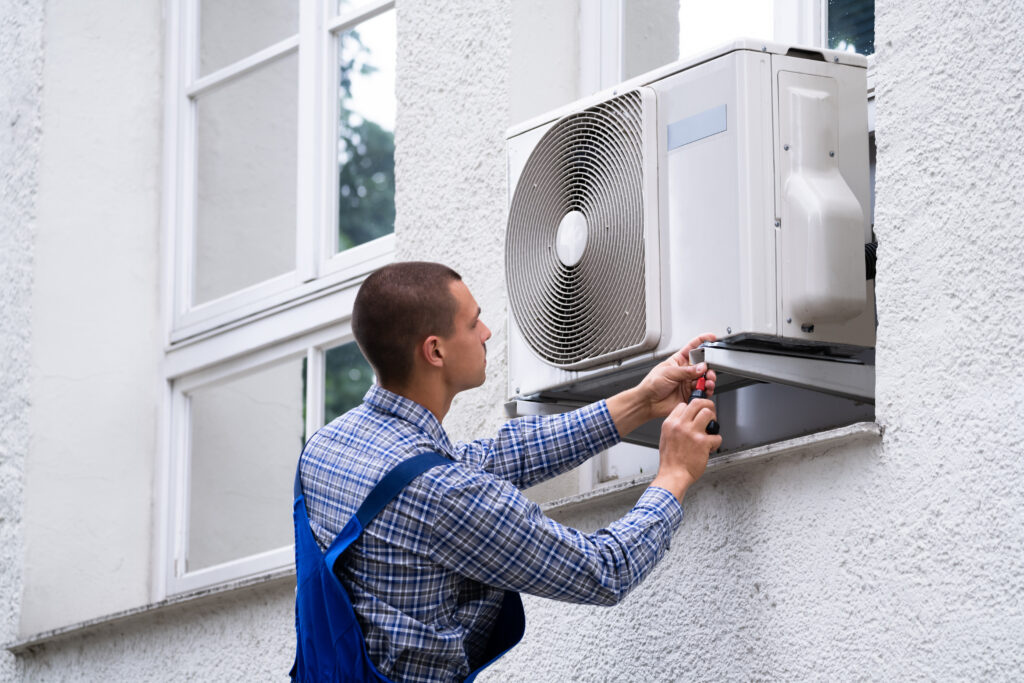 A heating and cooling professional installing a new ac unit at a residential property.