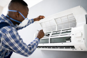 A heating and cooling professional opening up an HVAV unit to perform a diagnostic.