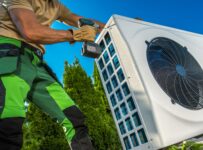 caucasian professional hvac technician installing heat pump