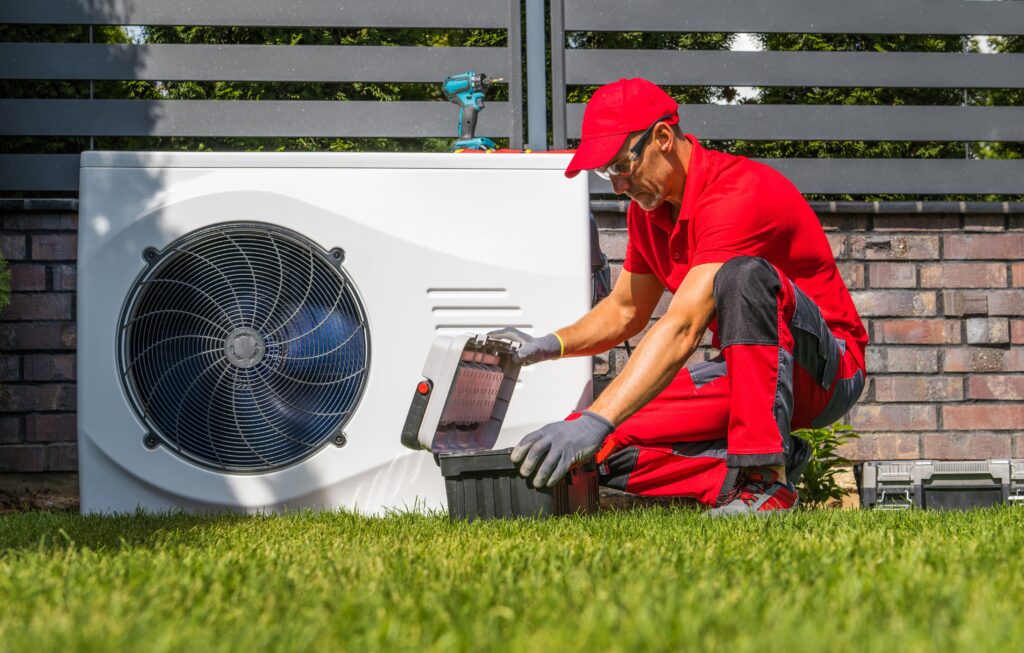 An HVAC technician dressed in all red opening his toolbox to begin and HVAC repair