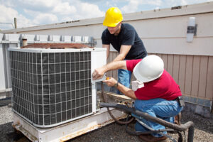 Two HVAC technicians repairing a system.