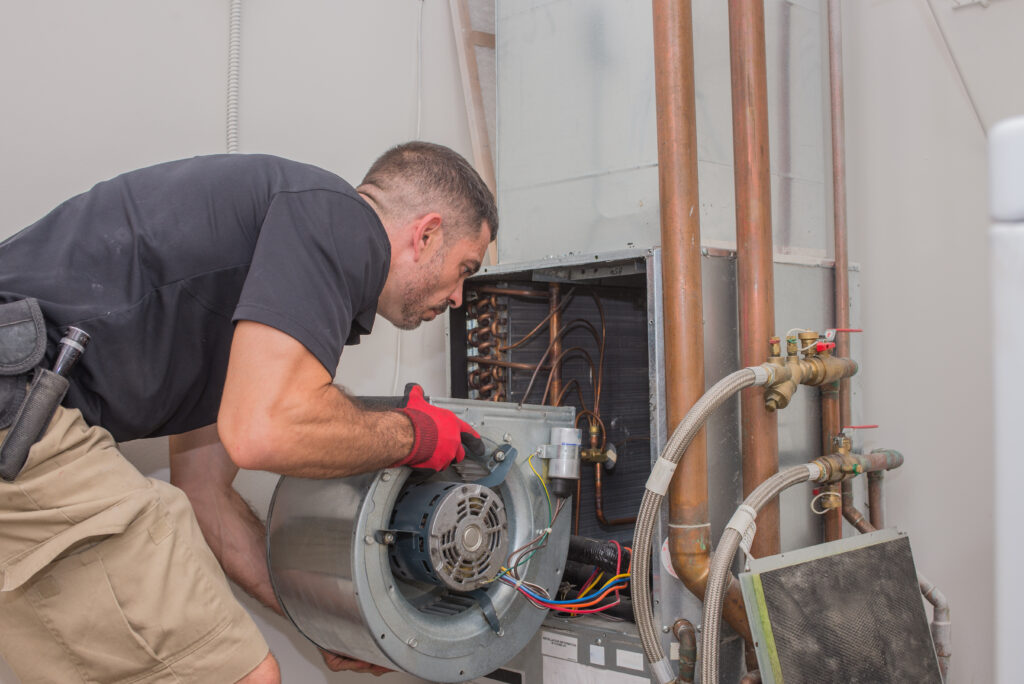 An HVAC technician replacing the motor on an HVAC unit