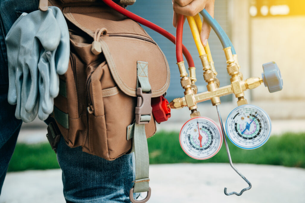 An HVAC technician carrying his diagnostic equipment in preparation for an AC repair