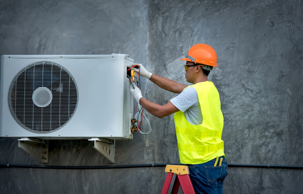 technician checking outdoor ac unit