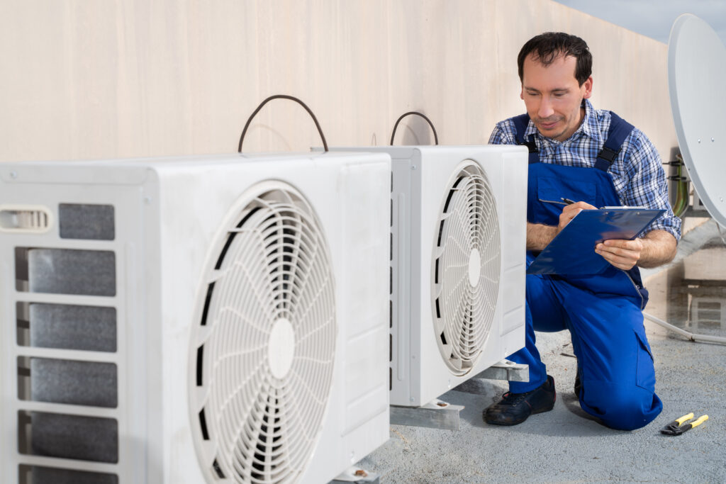 Man performing HVAC system inspection in blue uniform