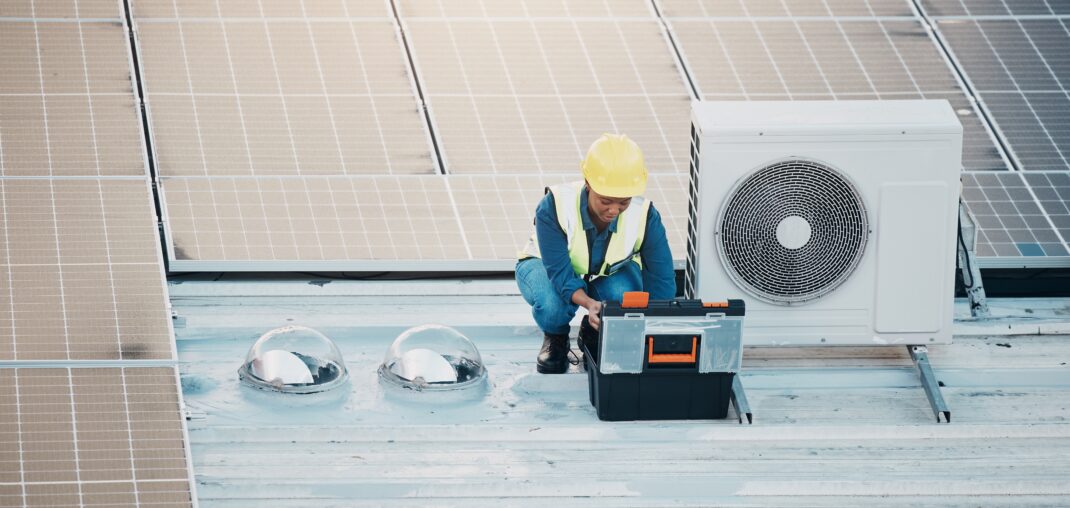 ac technician on roof with ac unit and solar