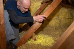 Home inspector inspecting blown in attic insulaiton.