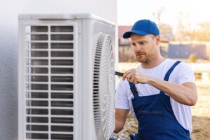 young hvac technician working on an outdoor unit