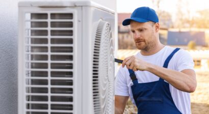 young hvac technician working on an outdoor unit
