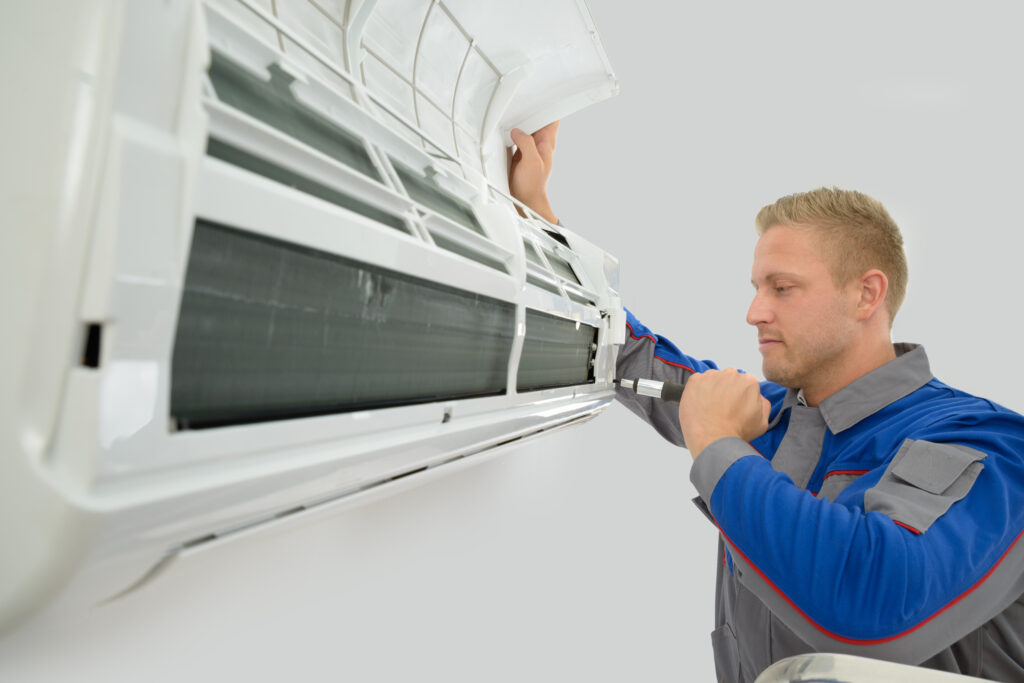 young male technician repairing an hvac unit