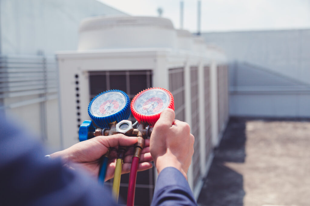 technician checking ac unit with measuring equipment