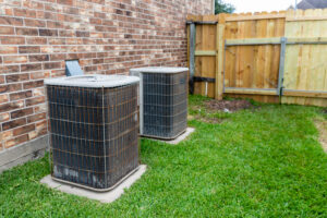 two older hvac units next to residential home