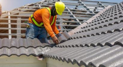 roof repair worker with white gloves replacing tile