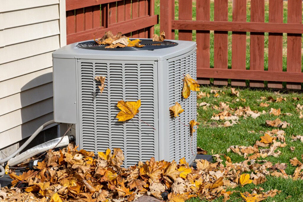 ac unit covered in leaves during autumn