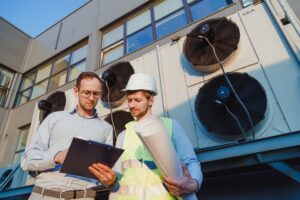 two men servicing hvac unit outdoors