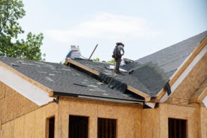 worker installing asphalt shingles