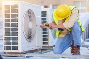 ac technician working on system on the roof of a building