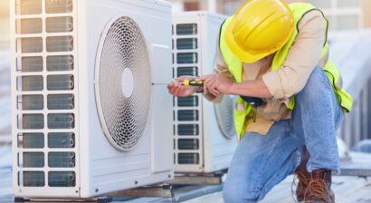 ac technician working on system on the roof of a building