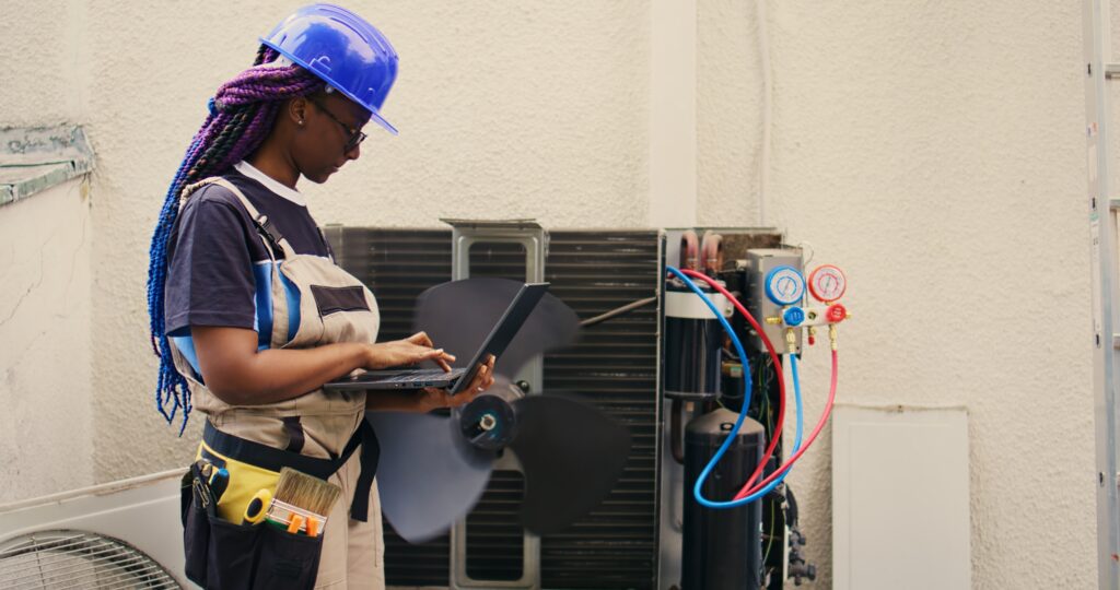 hvac technician working on outdoor hvac unit