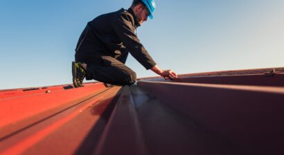 young man in helmet working on roof