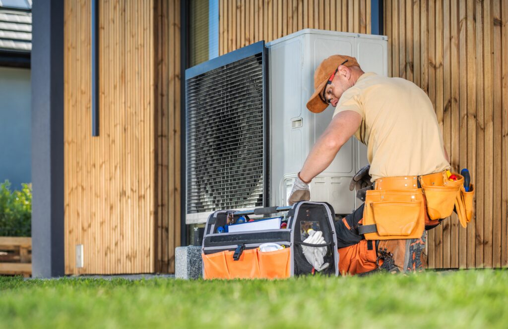 hvac technician working on a modern heat pump outdoors