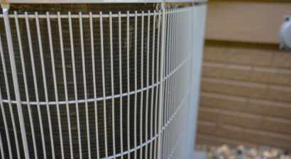 residential ac unit outdoors with fan and coils
