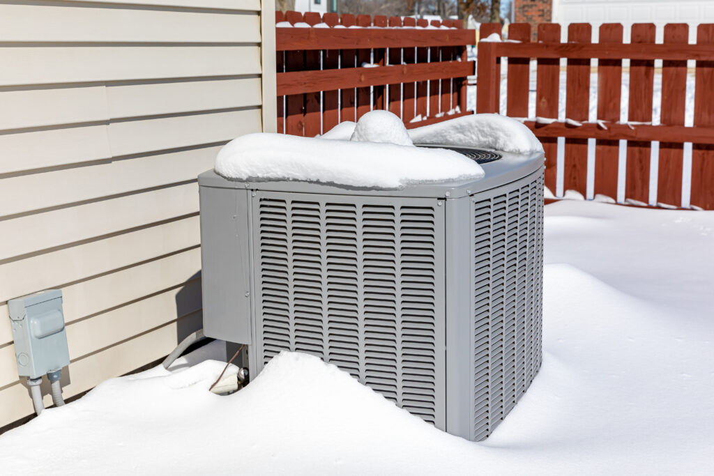 house ac unit covered in snow during winter