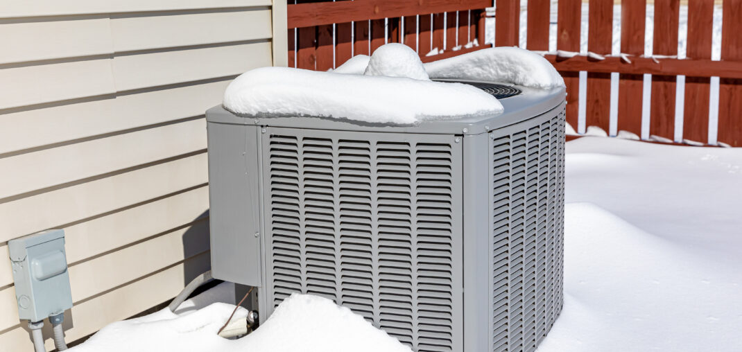 house ac unit covered in snow during winter