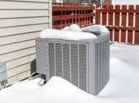 house ac unit covered in snow during winter