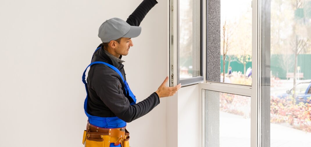 construction worker installing new windows in house