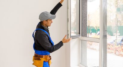 construction worker installing new windows in house