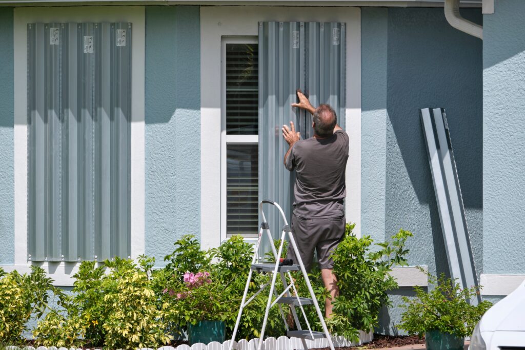 homeowner boarding up windows