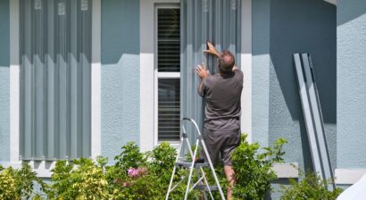 homeowner boarding up windows