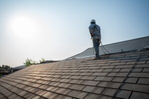 a roof repairman repairing the roof of house