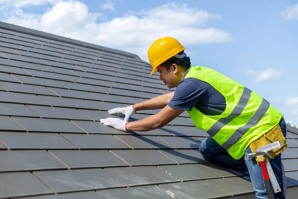 roof worker replacing tiles with gloves on