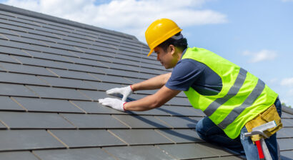 roof worker replacing tiles with gloves on