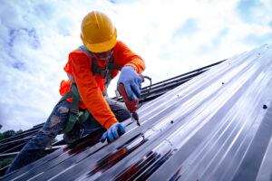 roofer working on construction of metal roof